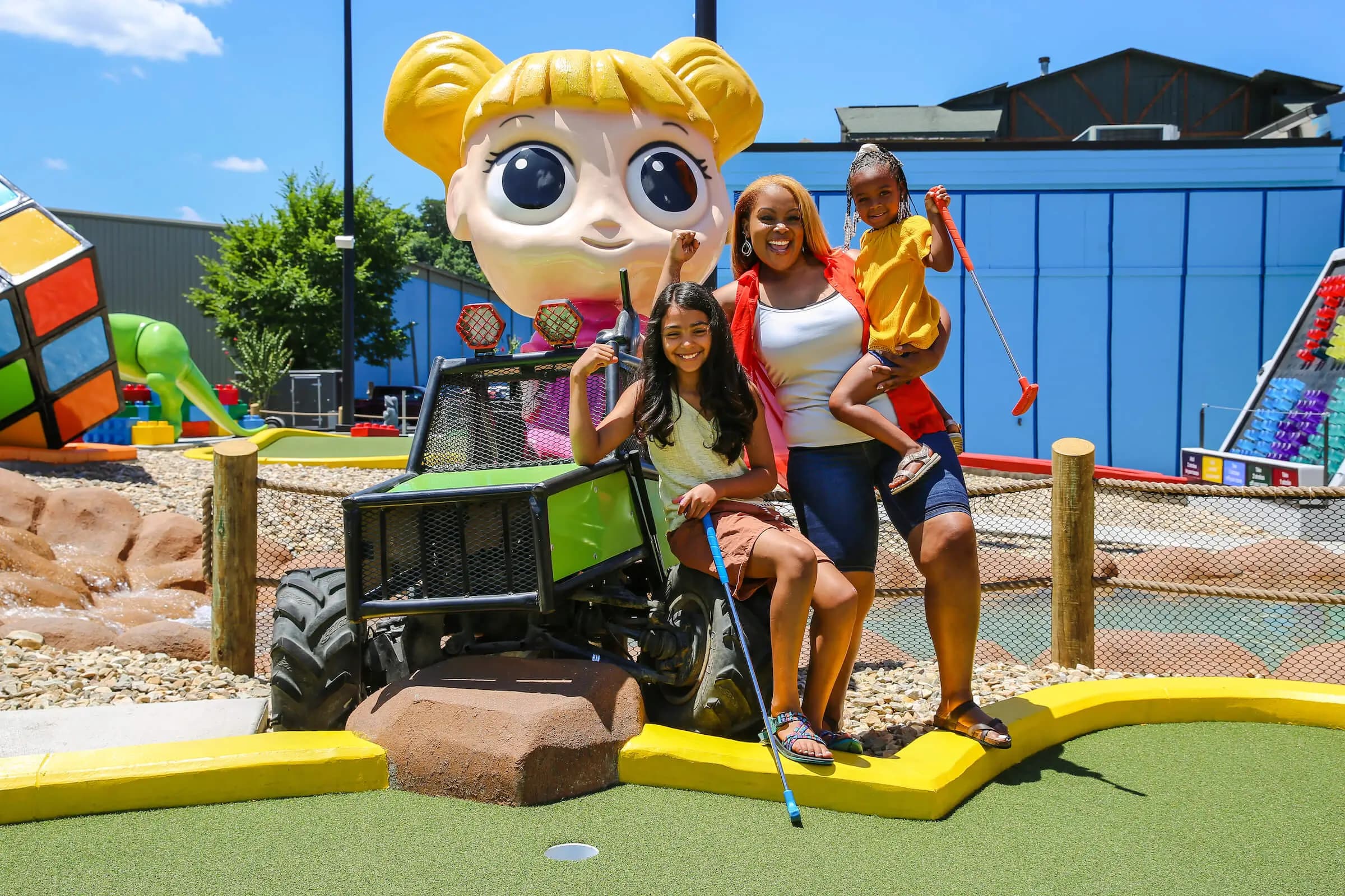 Mini Golf - Family in front of big doll golf cart