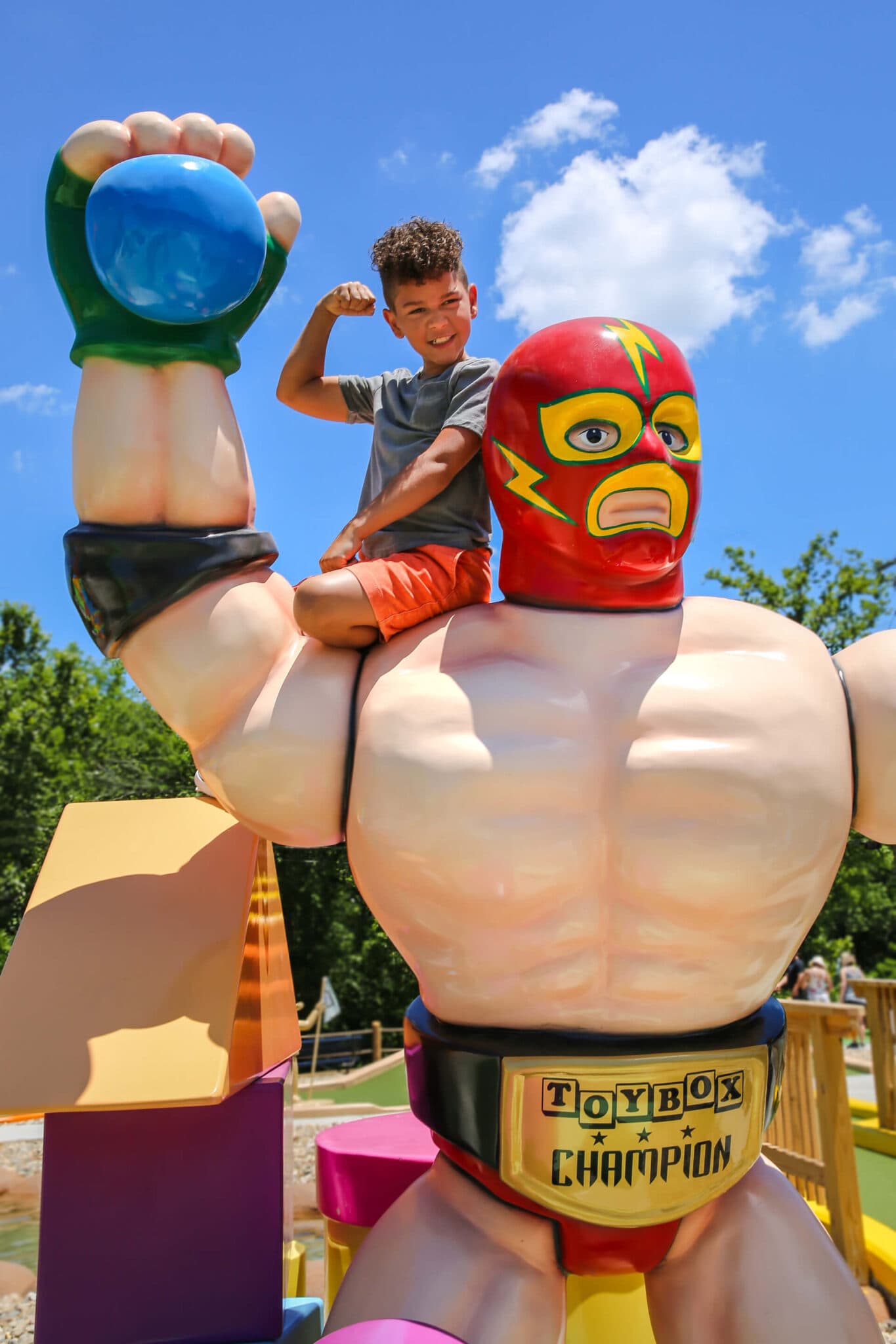 Boy getting photo next to strong-man statue