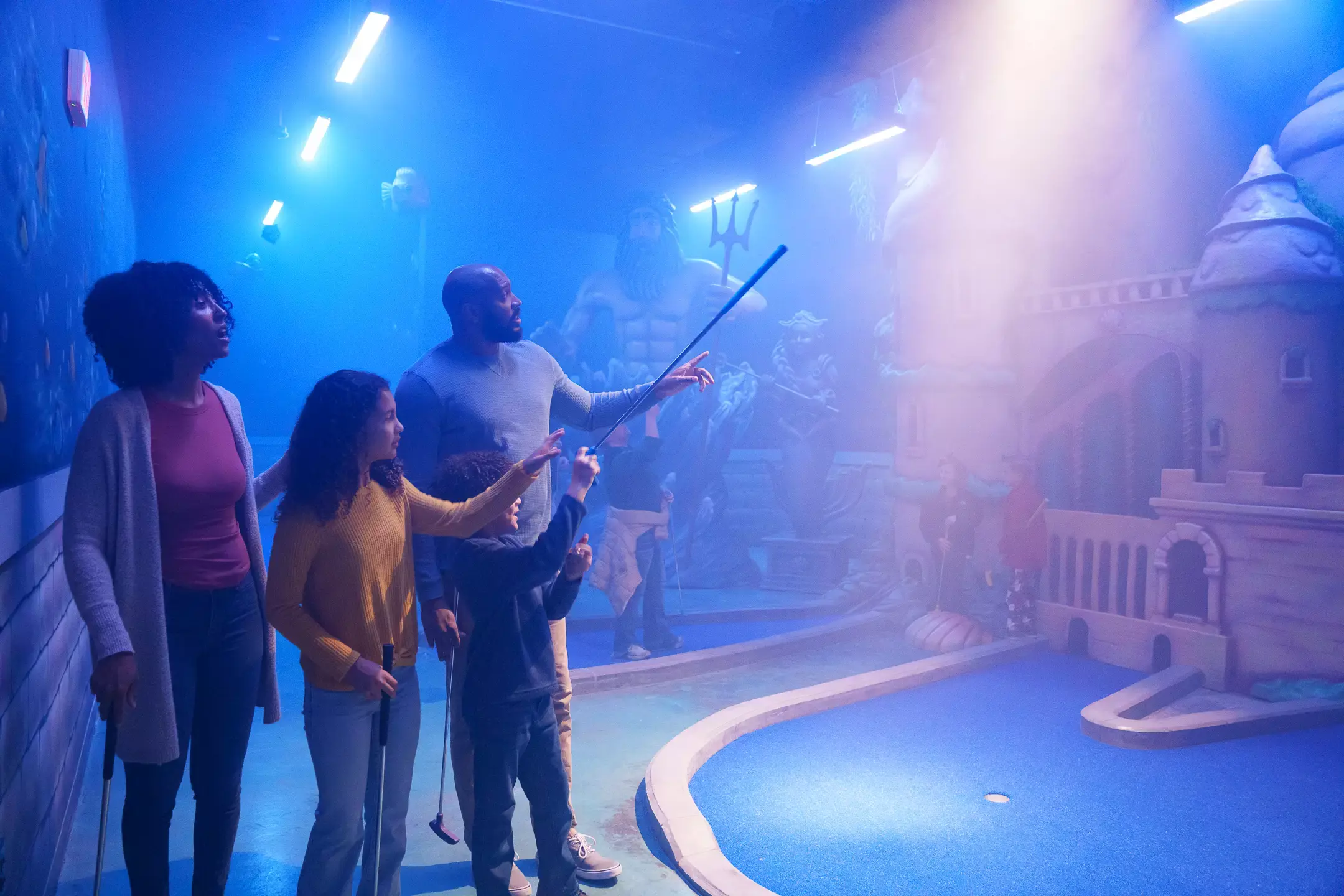 family at indoor mini golf course